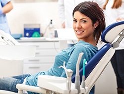 Happy dental patient with crowns smiling at camera