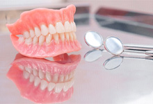 Dentures sitting on a glass surface