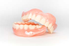 Full set of upper and lower dentures in Marshall against neutral background