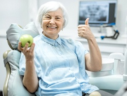 Senior dental patient enjoying benefits of implant-retained dentures