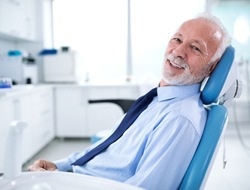Male senior dental patient happy with his implant-retained dentures