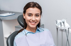 female dental patient in blue shirt smiling at camera