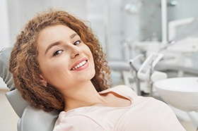 Young woman reclining in dental chair after cosmetic treatment
