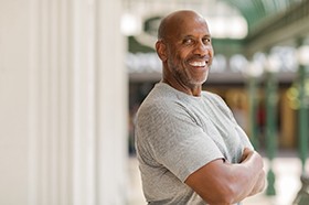 Confident man crosses arms and smiles with dental implants in Marshall