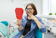 young woman admiring her new dental implants in Marshall
