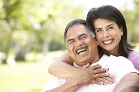 smiling couple with dental implants in Marshall