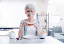 An elderly woman eating