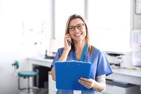 Dentist discussing dentures in Marshall with a patient over the phone