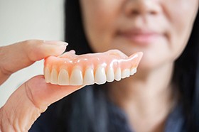 Woman holding a denture