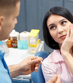 Woman visiting Marshall emergency dentist for a toothache 