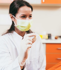 Dentist showing woman tooth after tooth extraction in Marshall