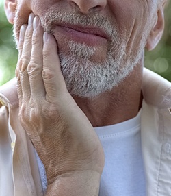 Man with toothache holding mouth in pain