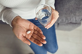 Woman preparing to swallow pill for oral conscious sedation