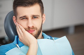 man holding his face needing a root canal in Marshall (for Factors section)