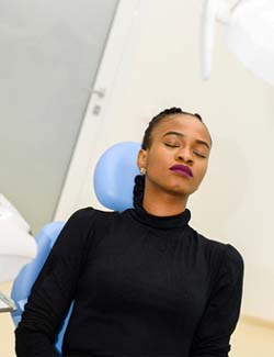 Woman relaxing in dental chair after oral conscious sedation in Marshall, TX