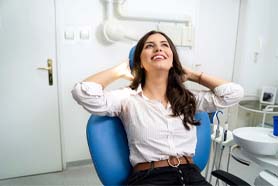 Woman smiling in dental chair after oral conscious sedation in Marshall, TX