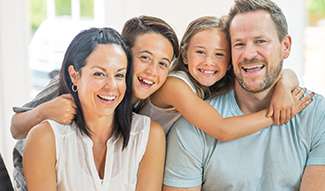 husband and wife laughing with kids
