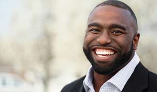 man smiling while wearing suit