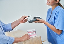 Patient paying for treatment at dental office front desk