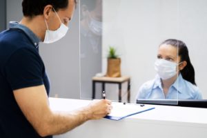 dental team member and patient wearing masks during check-in