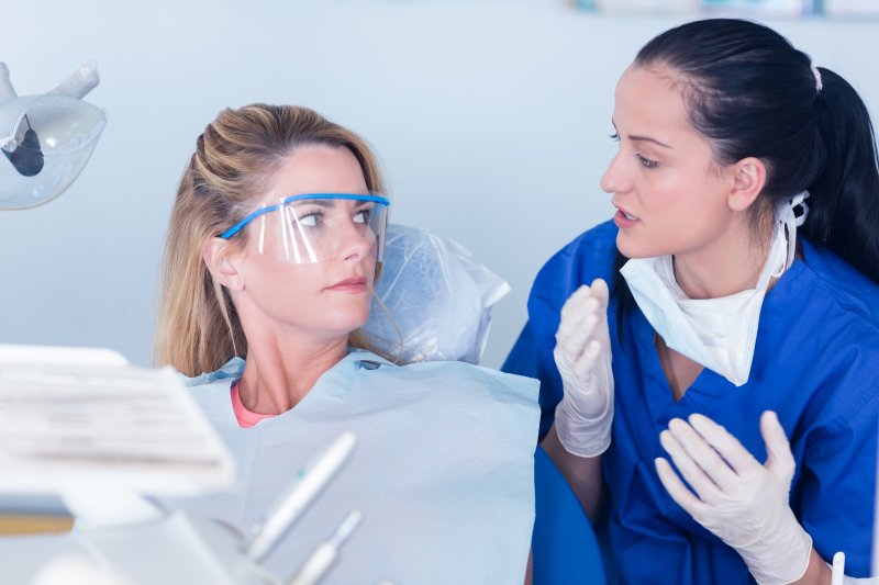 person whose dental bridge fell out talking to dentist