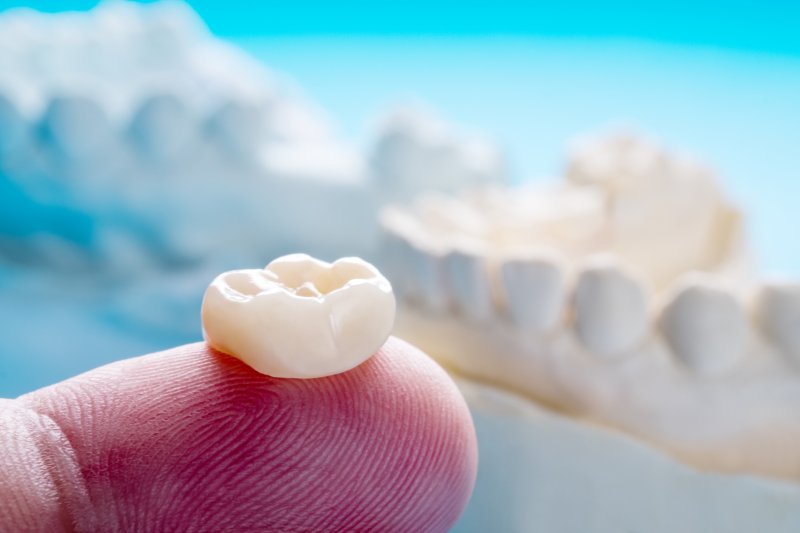 Close-up of a lost dental crown on a person’s finger