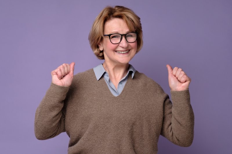 Older woman smiling with her new dentures