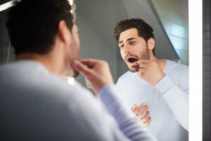Man checking his gums for signs of gingivitis